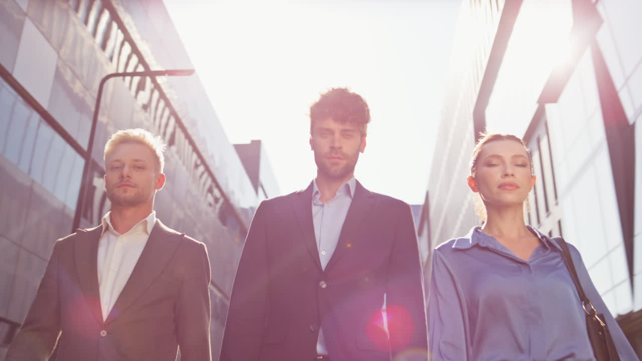 비즈니스 팀이 다운타운 거리에서 함께 고 있습니다. 자신감있는 사람들이 카메라를 봅니다.