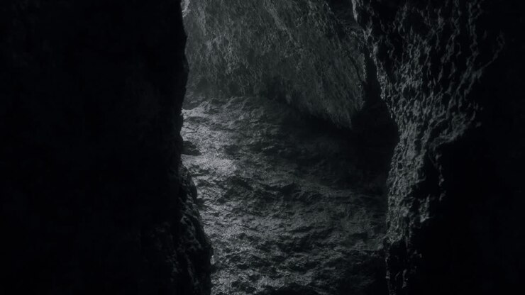 Cinematic shot through dripping cave seeking for light