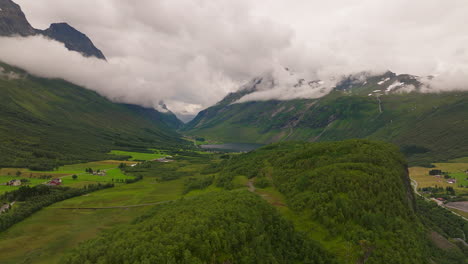 heaven in the norwegian countryside with white clouds above green valley