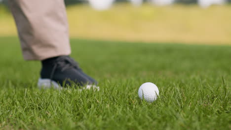 um homem afro-americano a bater uma bola de golfe no campo de golfe.