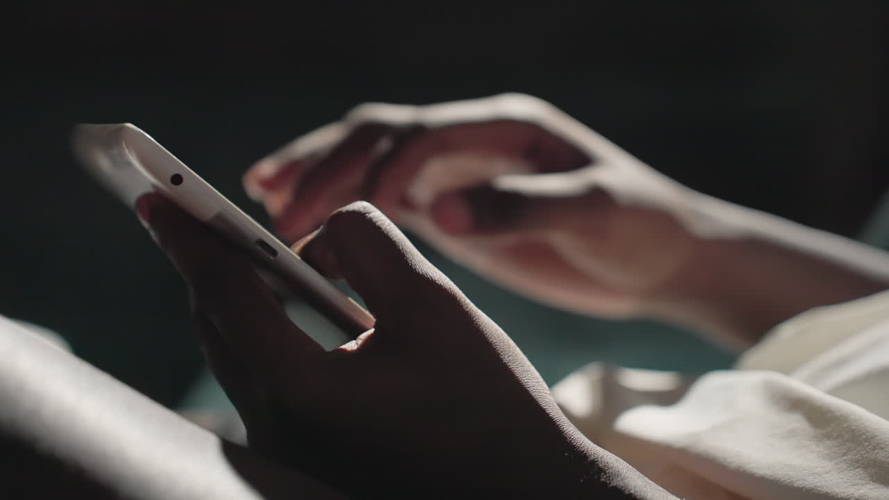 Close-up of Black youth's hands using a tablet, tapping on the screen with focus, highlighting finger movement in natural light, interacting with digital content in a relaxed indoor setting