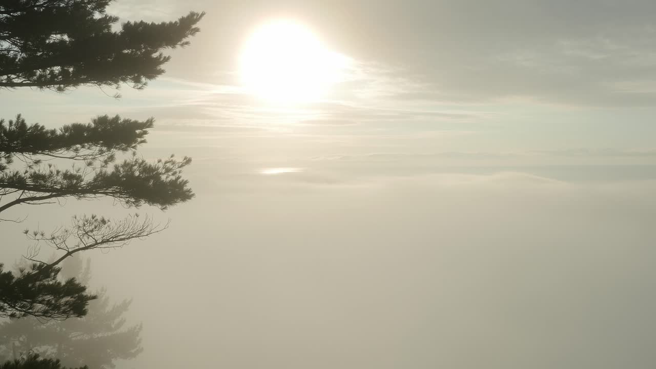 아침 안개가 굴러 들어오는 벌거벗은 절벽에서 우월한 호수 위로 일출