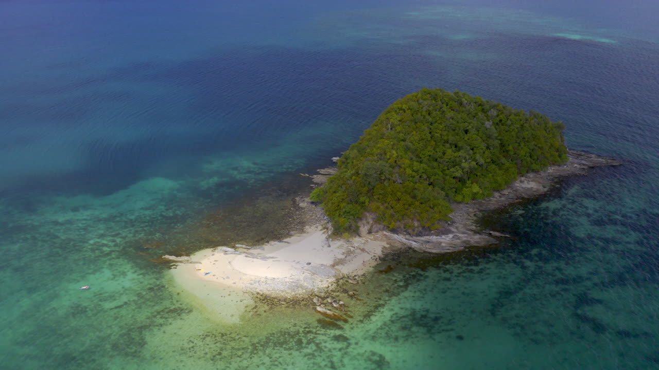 Aerial View of a Secluded Tropical Island with Clear Turquoise Water and Sandy Beach