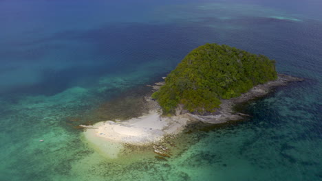 aerial view of a secluded tropical island with clear turquoise water and sandy beach