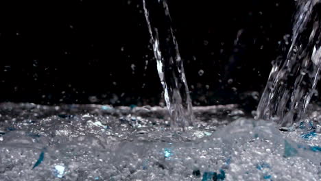 glittery and shiny water pouring into black background with blue glitter and crystals