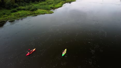 drone shot of two kayaks in the river, people are kayaking