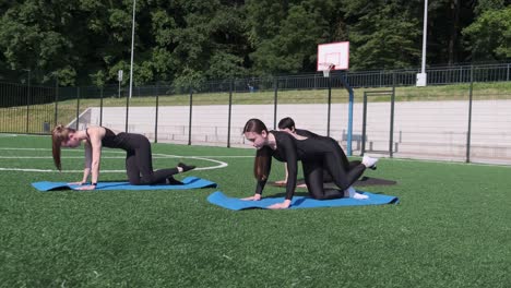 women performing dynamic fitness training on outdoor exercise mats group of women engaged in energetic fitness training on mats in an outdoor setting showcasing strength agility and endurance exercises