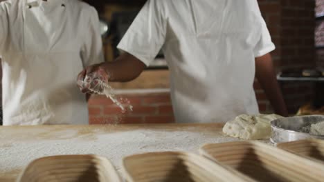 animation of midsection of diverse male and female bakers pouring flour on board