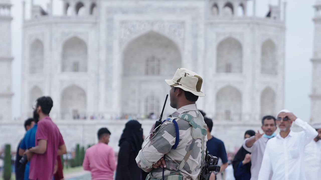 homem militar indiano em frente ao taj mahal