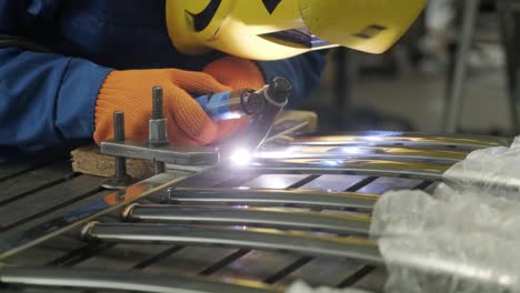 man wearing mask welding in a workshop. metal workers use manual labor. skilled welder. welder is welding the stainless steel pipes in the factory. welder industrial part in factory.