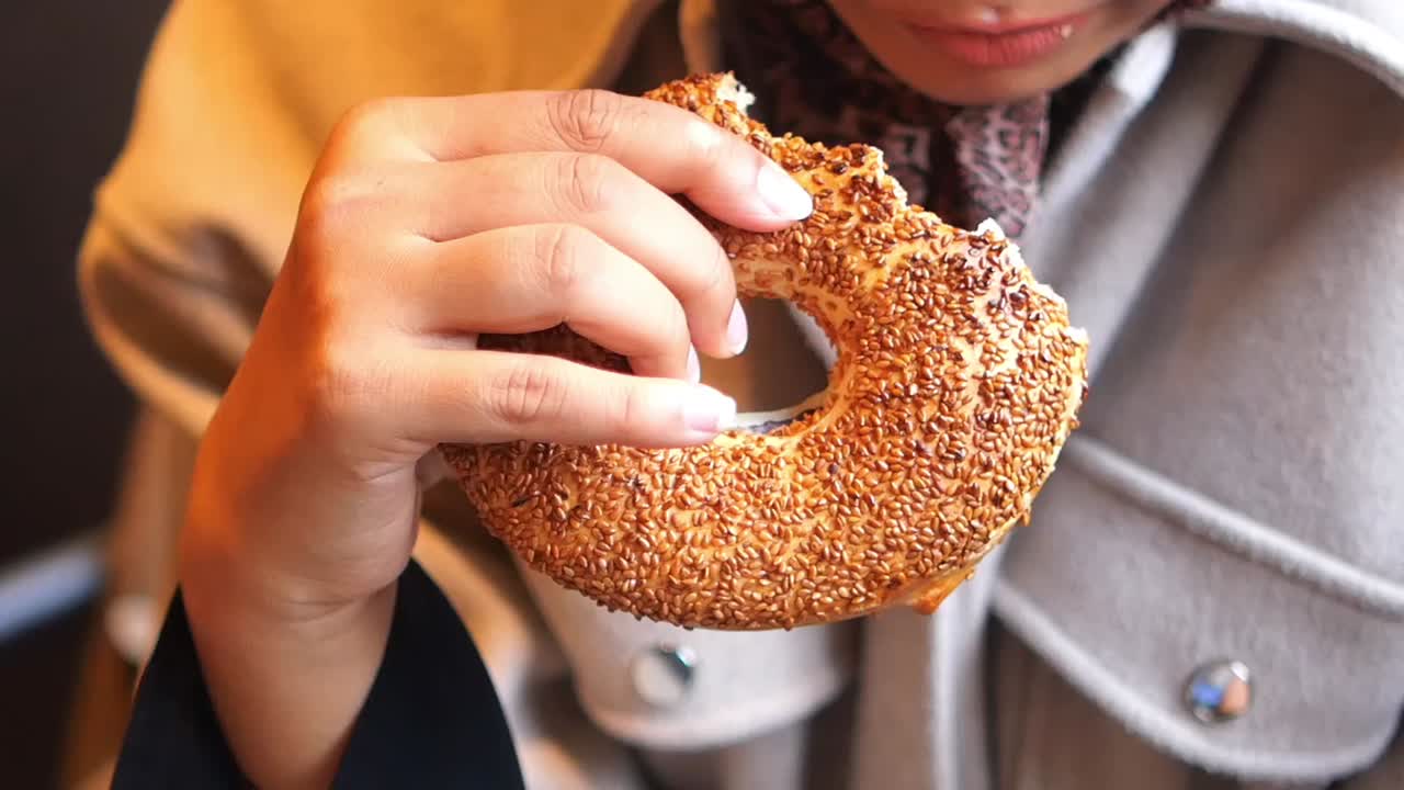 A person eating a sesame simit