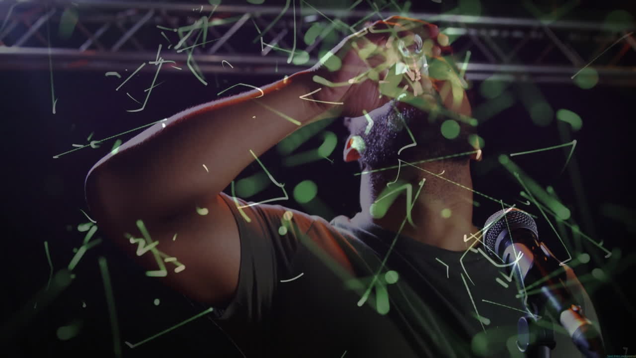 Solo performer holding glass at microphone on stage, showing technology with green network overlay