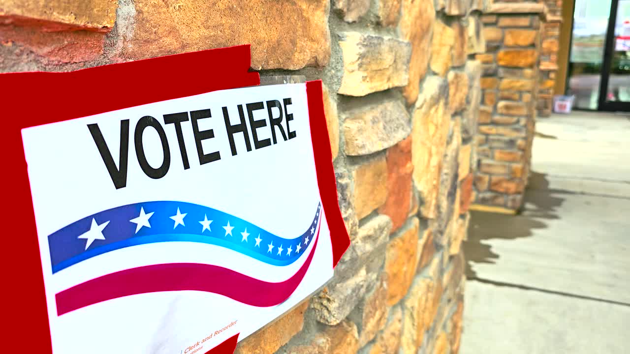 Vote Here sign displayed prominently in sharp close-up, symbolizing the democratic process and civic responsibility. Perfect for news reporting, campaign ads, and educational election materials