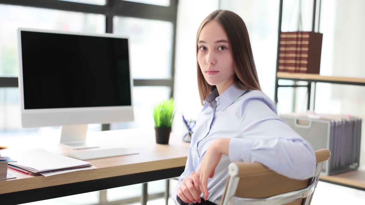 Young woman working or studying at an office desk with a computer