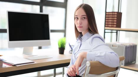 young woman working or studying at an office desk with a computer
