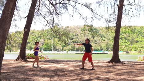 couple playing badminton by the lake