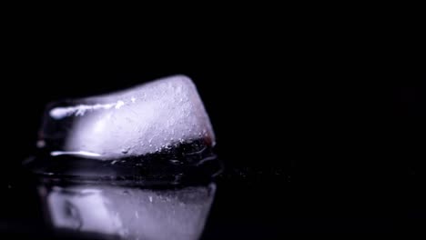 ice cube melting - black background - time lapse