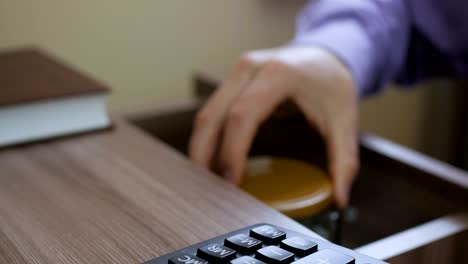 caucasian male putting a glass jar put in a drawer  table with his savings for donation