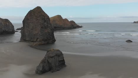 todavía aérea de olas rompiendo la playa de arena oscura de oregon de la autopista 1 de la costa del pacífico, ee.uu.