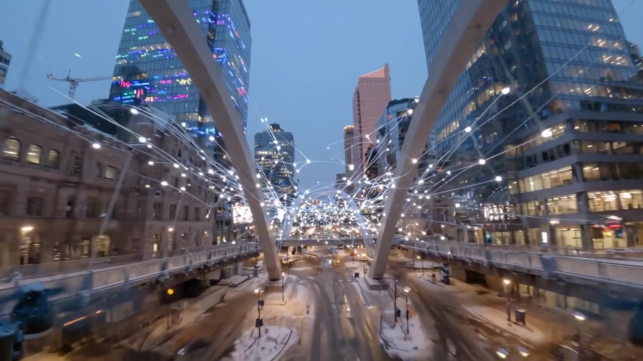 A mesmerizing winter evening cityscape, showcasing dazzling lights amidst towering skyscrapers and snowy streets in a bustling urban environment.