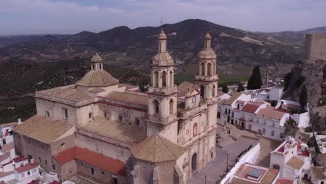 flying close at olvera church spain with mountains in the background, aerial