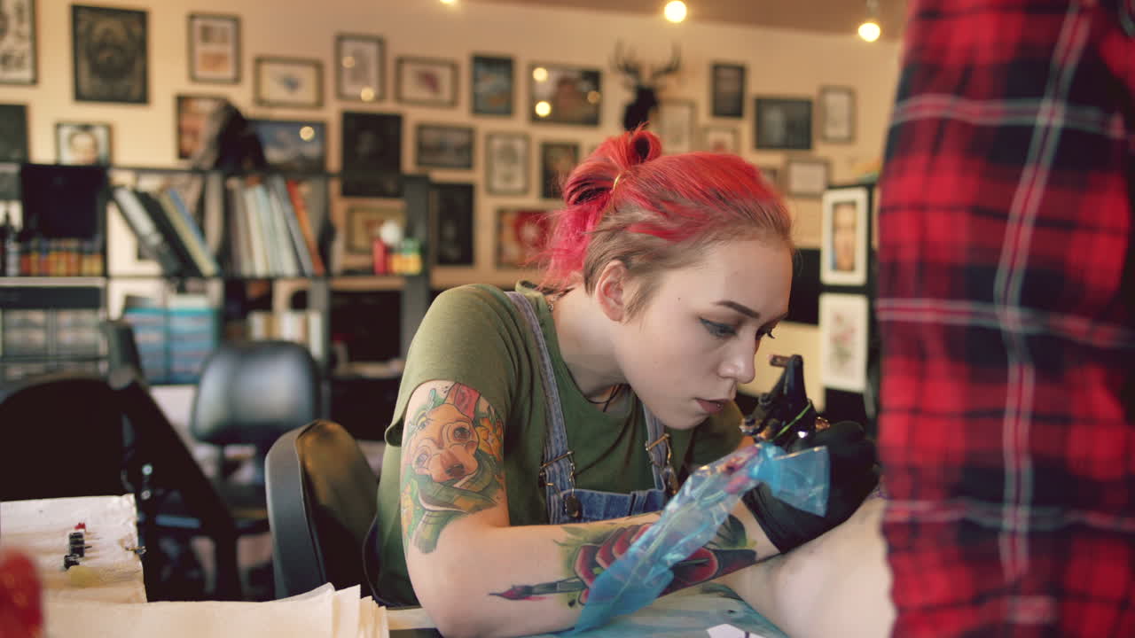 Tattoo artist working on a client's arm
