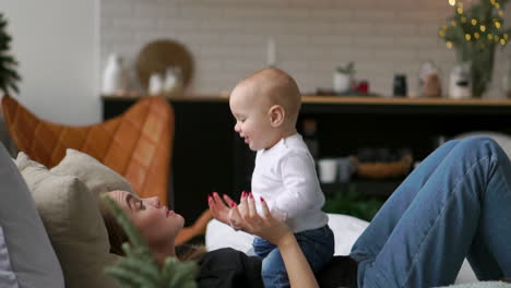 happy family. mother playing with her baby in the bedroom. laughing and smiling.