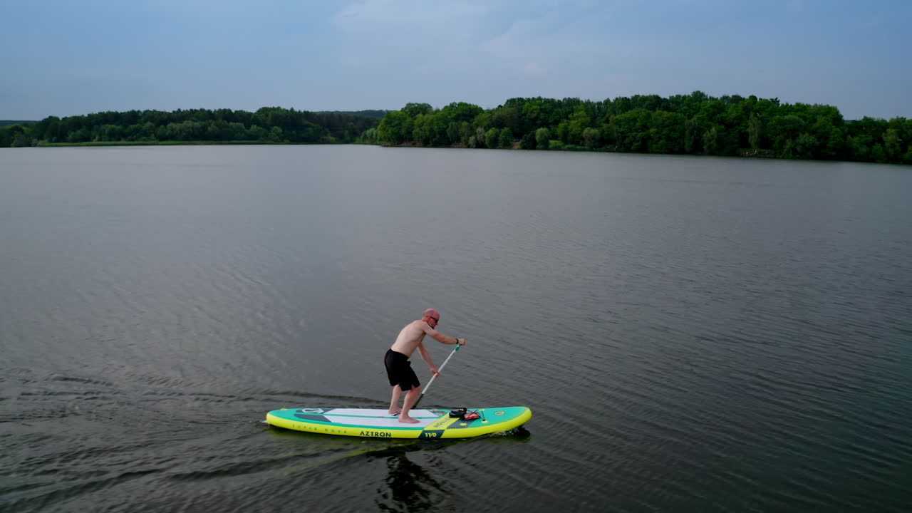 Man standing on sup board. Handsome young man on sup paddle standing board