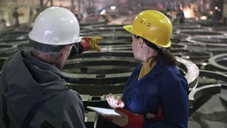 engineer talking to supervisor inspecting metal fabrication facility