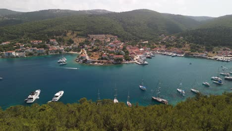 Drone-panning-across-sailing-yachts-in-Fiskardo-harbour,-Kefalonia-Greece