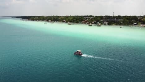 a catamaran with people sailing in lake bacalar, in qunatana roo, mexico