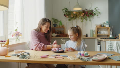 mom and little daughter preparing easter eggs