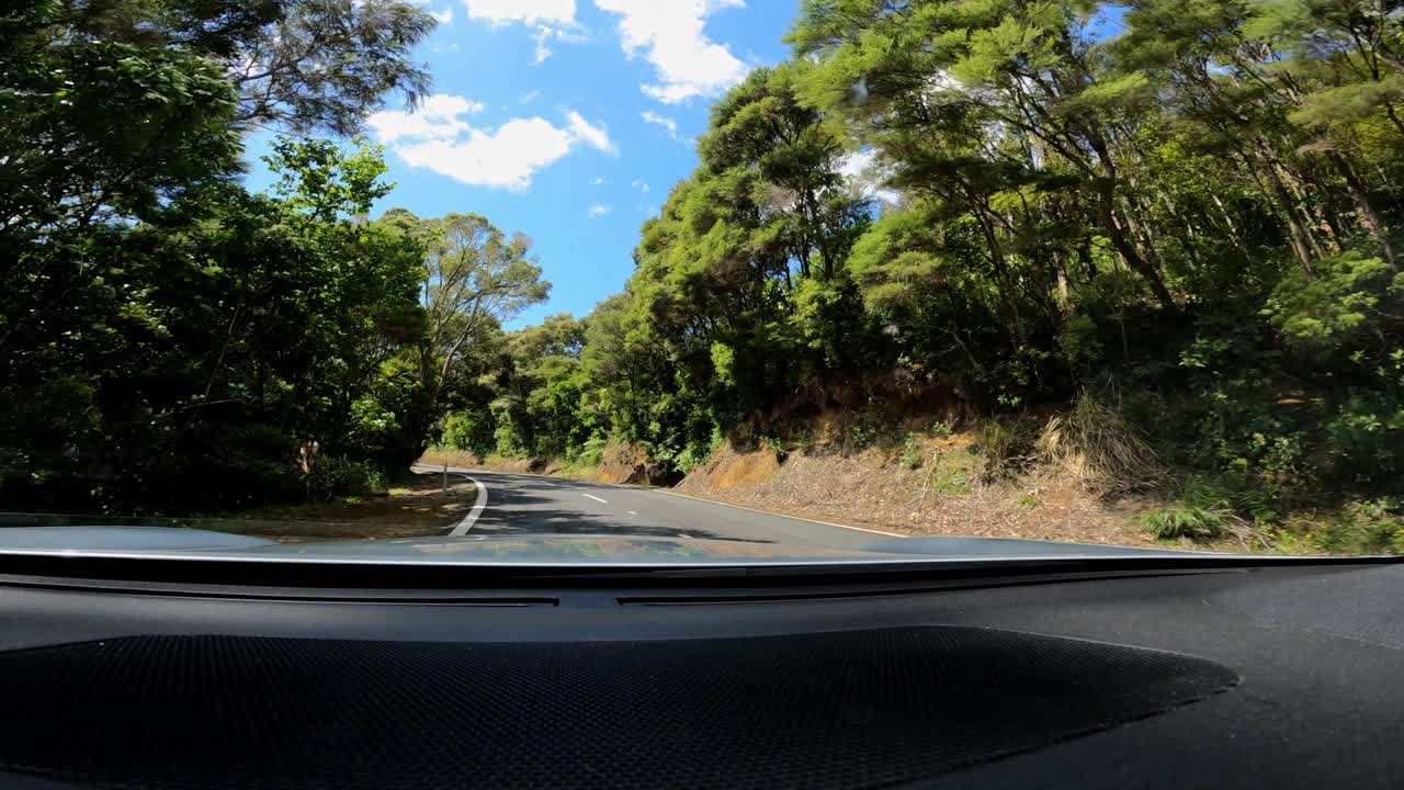 coche conduciendo en la carretera de asfalto en la costa de la península de coromandel de nueva zelanda.