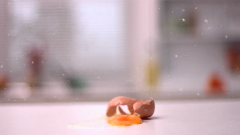 Animation-of-snow-falling-over-egg-cracking-in-kitchen