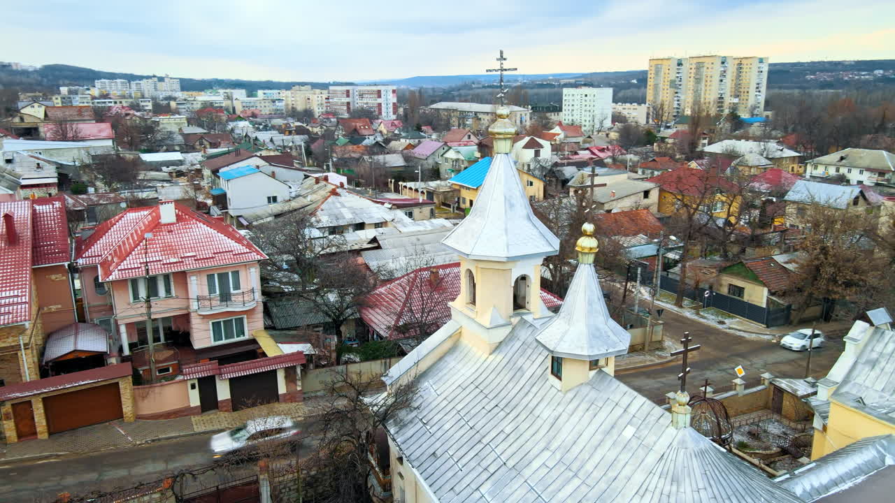 Letecký pohled dronem na kostel v Kišiněvě, Moldavsko. Několik budov, silnice, kostel, zamračené počasí, holé stromy, zima