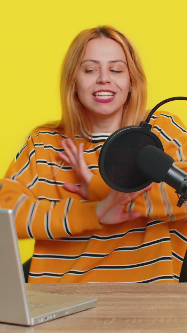 Blogger woman influencer recording podcast giving workshop webinar speaking in microphone and laptop