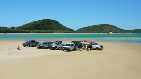 Drone-Aéreo-4k-Sobre-Autos-Con-Instalación-De-Campamento-En-La-Orilla-De-La-Playa-De-Arena,-Australia