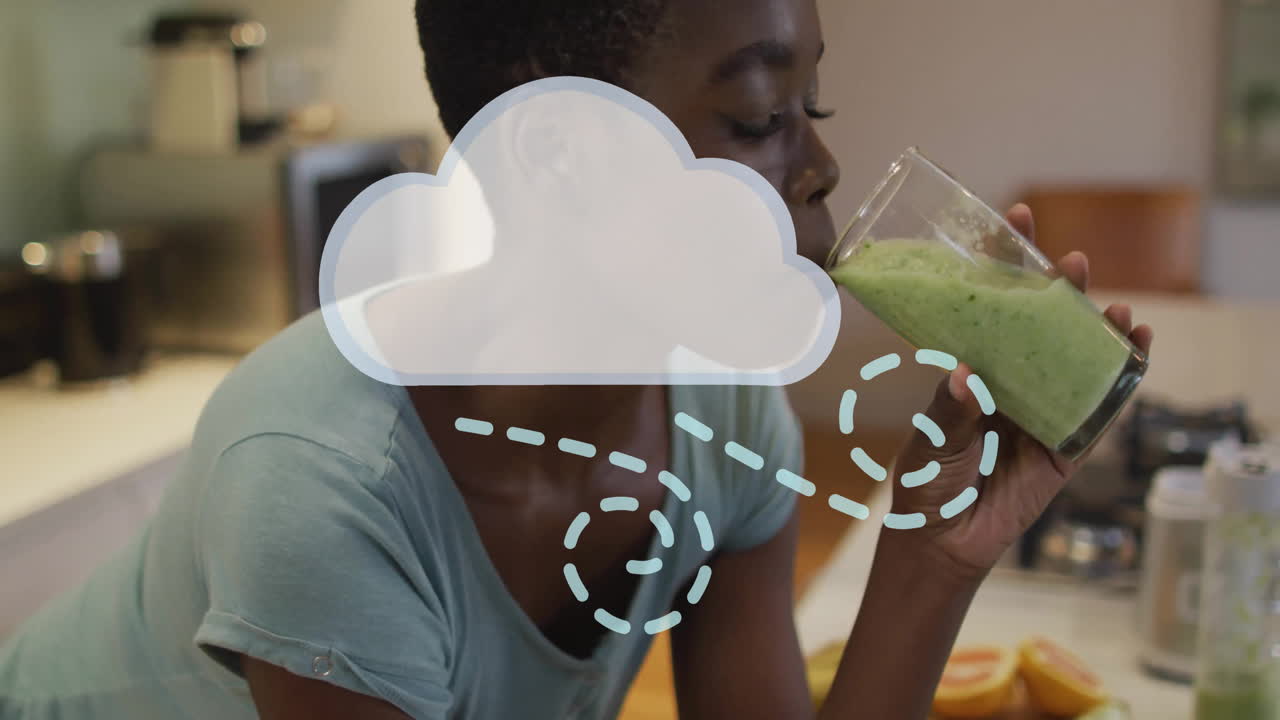 Woman holding green smoothie with cloud animation overlay in kitchen