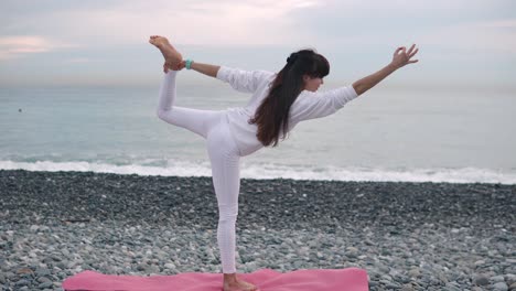 mujer practicando yoga en la playa