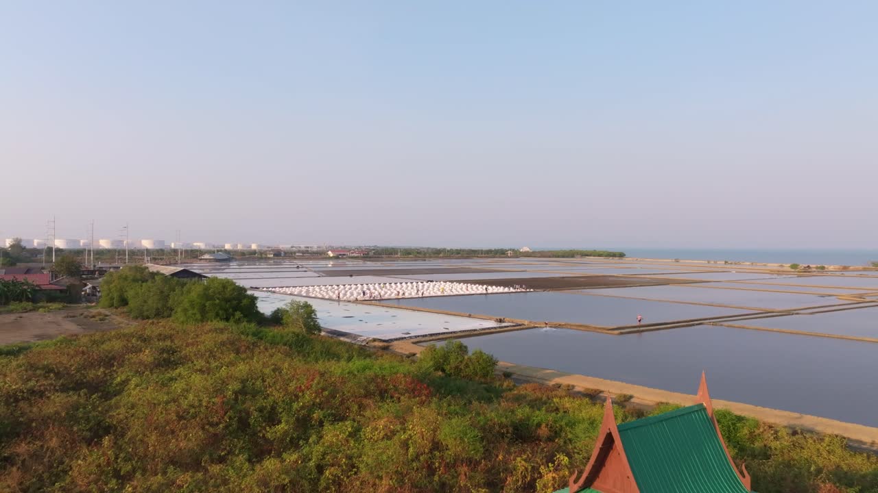 Ripresa con drone di lavoratori che raccolgono sale nella salina di Ban Laem, Thailandia