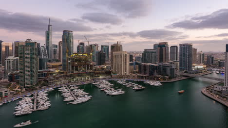 el lapso de tiempo de la transición del día a la noche del dubai marina yacht club desde la torre paloma