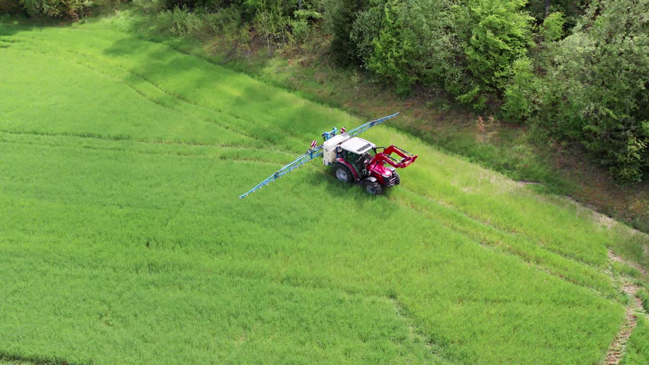 Bird's eye view of a Tractor spraying chemicals in a lush green field