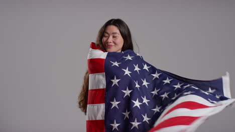 Studio-Portrait-Shot-Of-Woman-Wrapped-In-American-Flag-Celebrating-4th-July-Independence-Day-7