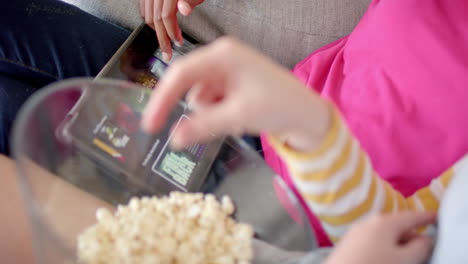 Diversas-Amigas-Adolescentes-Usando-Tabletas-Con-Películas-Y-Comiendo-Palomitas-De-Maíz-En-Casa,-Cámara-Lenta