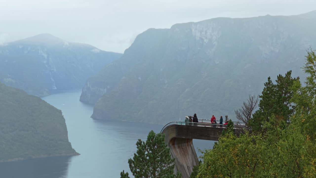Aerial footage of people at famous Stegastein skywalk above Aurlandsfjord, Norway