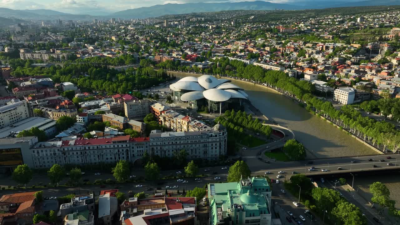 Aerial drone view of Tbilisi’s modern architecture and river landscape, featuring the House of Justice and contemporary buildings