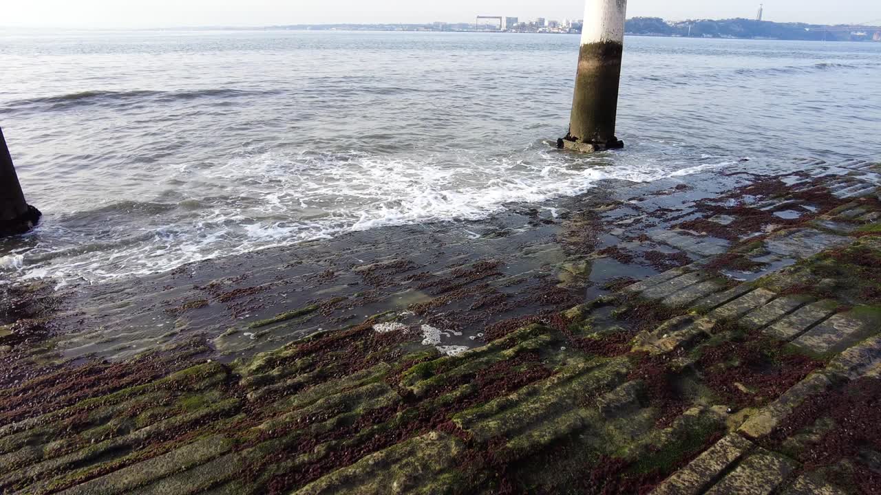포르투갈 리스본의 타구스 강에 두 개의 기둥이 있는 카이스 다스 콜루나스에 부서지는 파도