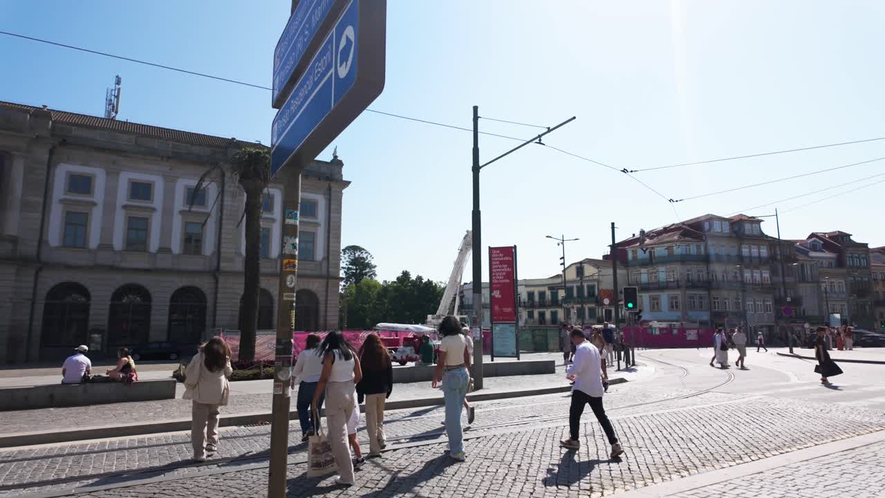 Sunny day at Praça de Gomes Teixeira, Porto, showing historic buildings, people, and a fountain