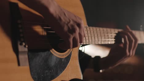 a handsome guy plays an acoustic guitar in an abandoned cinema. the musician sings a song and accompanies on the guitar