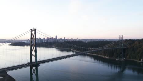 4k aerial footage of lions gate bridge in the morning looking at vancouver and stanley park moving towards bridge